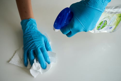 cleaning worktops with disinfectant spray