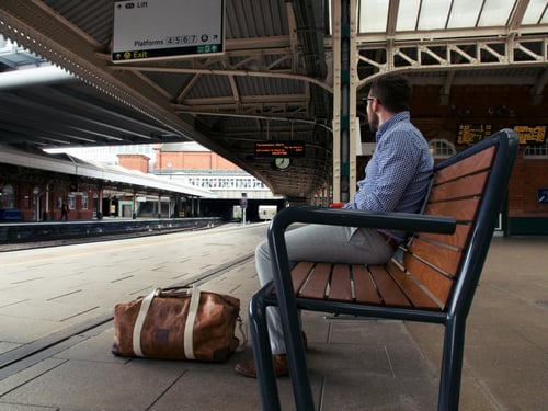 Middle aged businessman waits at train platform