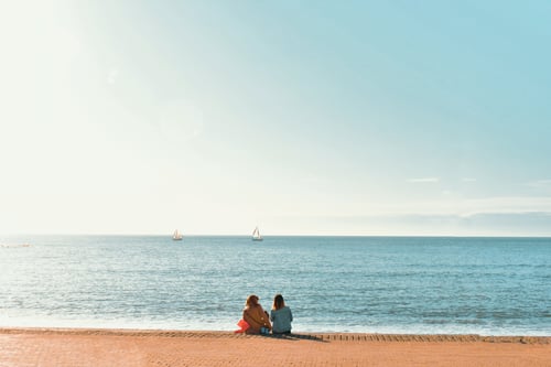 children sit on beach in Aberystwyth