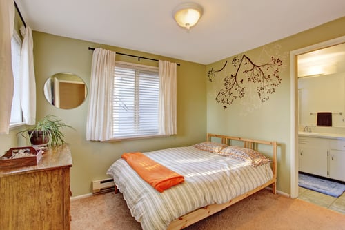 bright bedroom with green walls and striped bedding