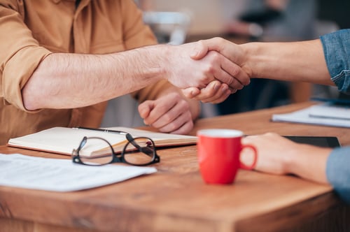 two men shake hands over business deal