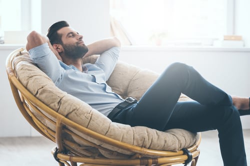 Smartly dressed man relaxes on sofa